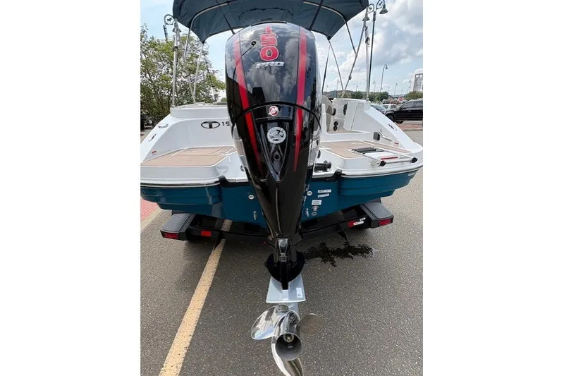 Slide: The Image of 2027 Tahoe 1950 boat with powerful outboard motor, parked on a road. - 2