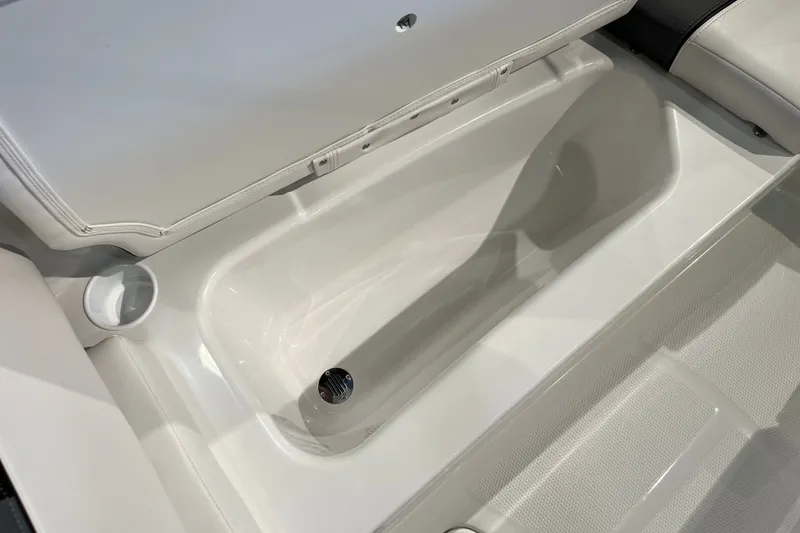 Slide: The Image of 2027 Tahoe T16 boat storage compartment with white interior and cup holder. - 29