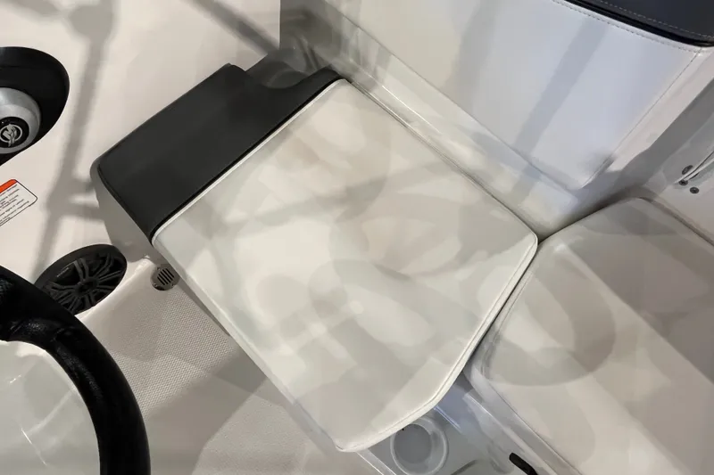 Slide: The Image of 2027 Tahoe T16 boat interior with white and black seating, steering wheel, and speaker. - 25
