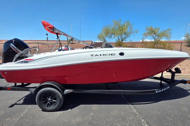 The Image of 2027 Tahoe T18 boat with red and white design on a trailer, parked outdoors. - 0