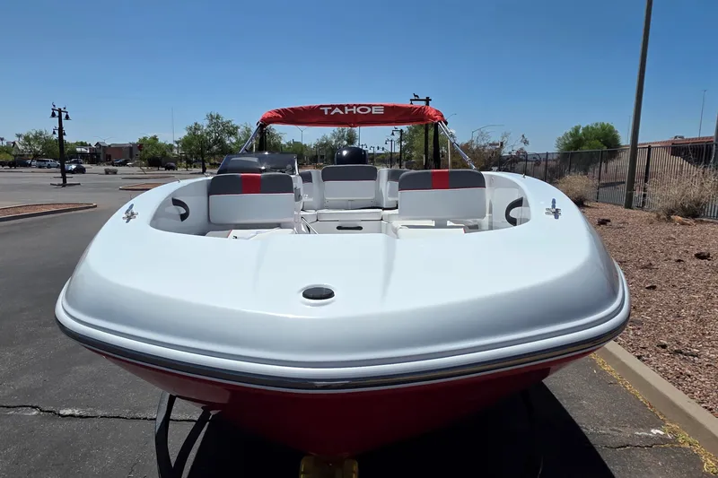 Slide: The Image of 2027 Tahoe T18 boat with red and white seating, parked outdoors under clear blue sky. - 3