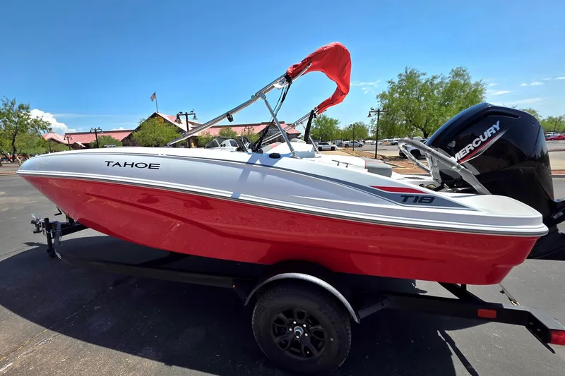 Slide: The Image of 2027 Tahoe T18 boat with red hull and Mercury engine on trailer. - 2