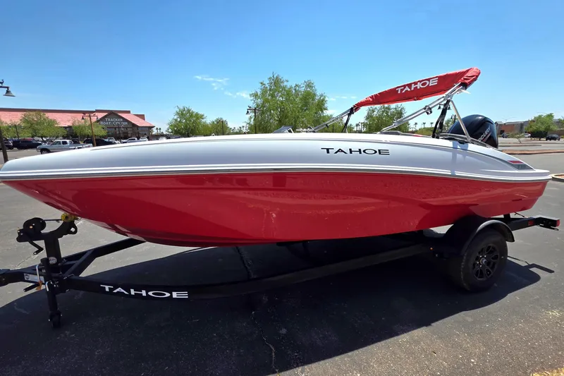 Slide: The Image of 2027 Tahoe T18 boat with red hull and canopy on trailer in parking lot. - 1