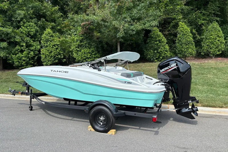 Slide: The Image of 2027 Tahoe T16 boat with Mercury outboard motor on a trailer, parked outdoors. - 3