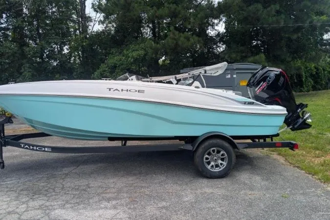 The Image of 2027 Tahoe T18 boat on trailer, light blue hull, parked outdoors. - 0