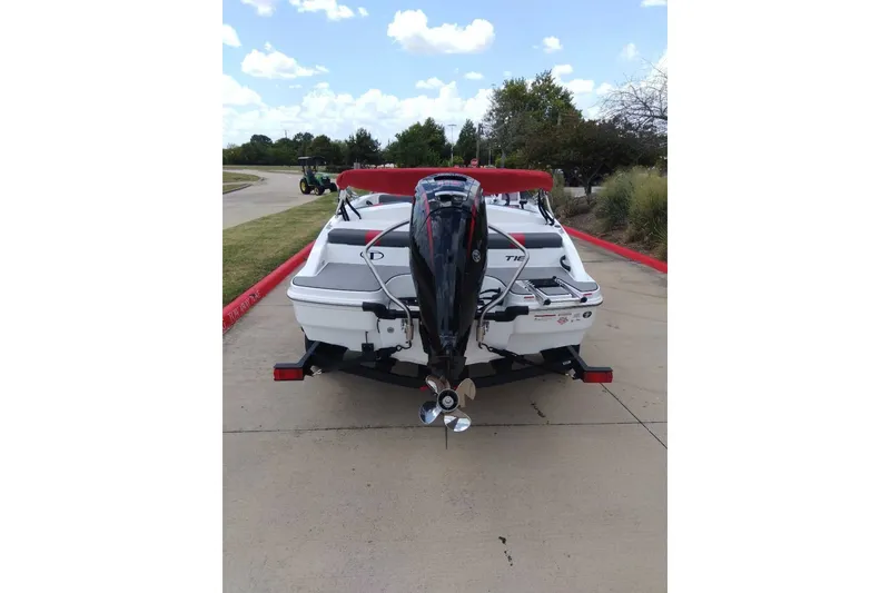 Slide: The Image of 2027 Tahoe T18 boat on trailer, rear view with outboard motor, parked on concrete. - 3