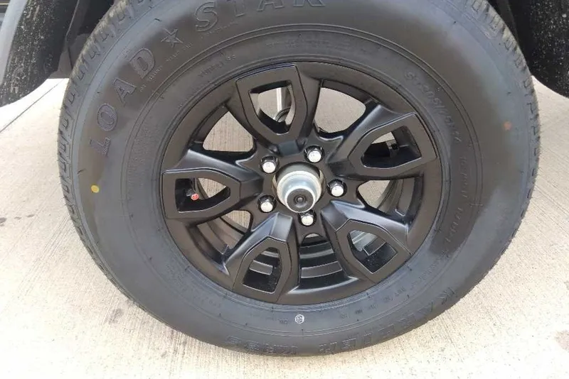 Slide: The Image of Black alloy wheel of 2027 Tahoe T18 with Load Star tire on concrete surface. - 10