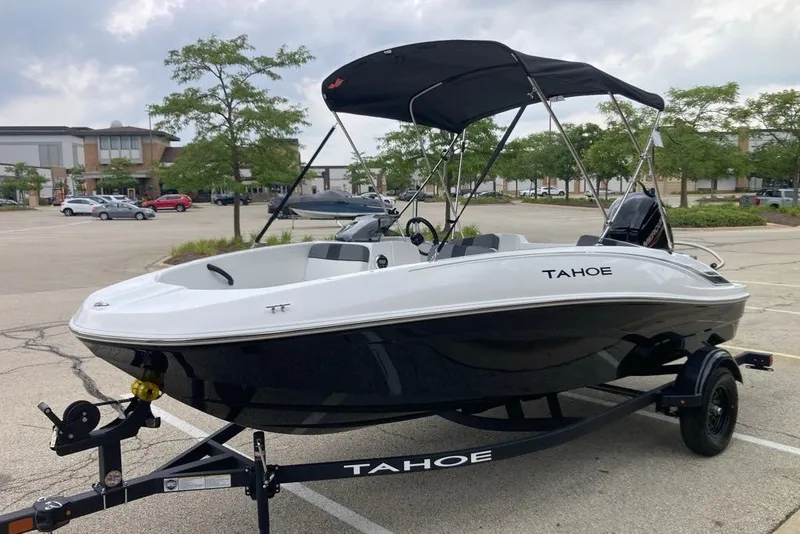 Slide: The Image of 2027 Tahoe T16 boat with canopy on trailer in parking lot. - 2