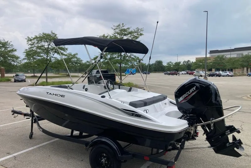 Slide: The Image of 2027 Tahoe T16 boat with Mercury engine in parking lot, featuring sleek design and canopy. - 9
