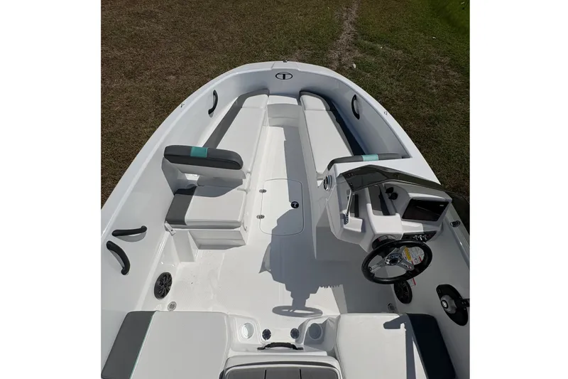 Slide: The Image of 2027 Tahoe T16 boat interior with seating and steering console on grassy background. - 11
