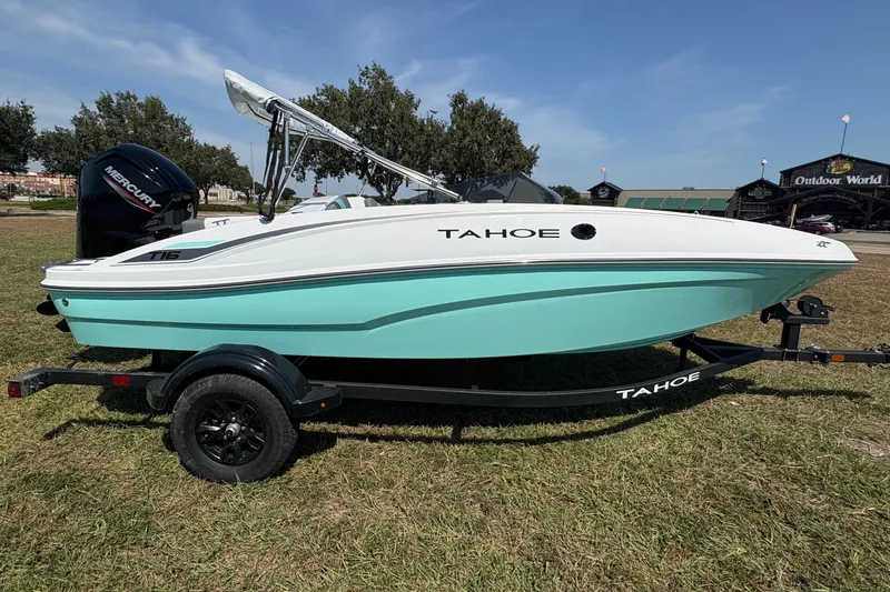 Slide: The Image of 2027 Tahoe T16 boat on trailer, displayed outdoors with trees and building in background. - 6