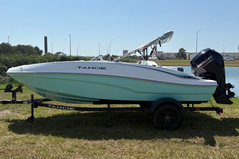 Slide: The Image of 2027 Tahoe T16 boat on trailer by a lake, sunny day, grassy area. - 2