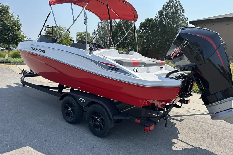 Slide: The Image of Red and white 2027 Tahoe T21 boat with outboard motor on trailer. - 1
