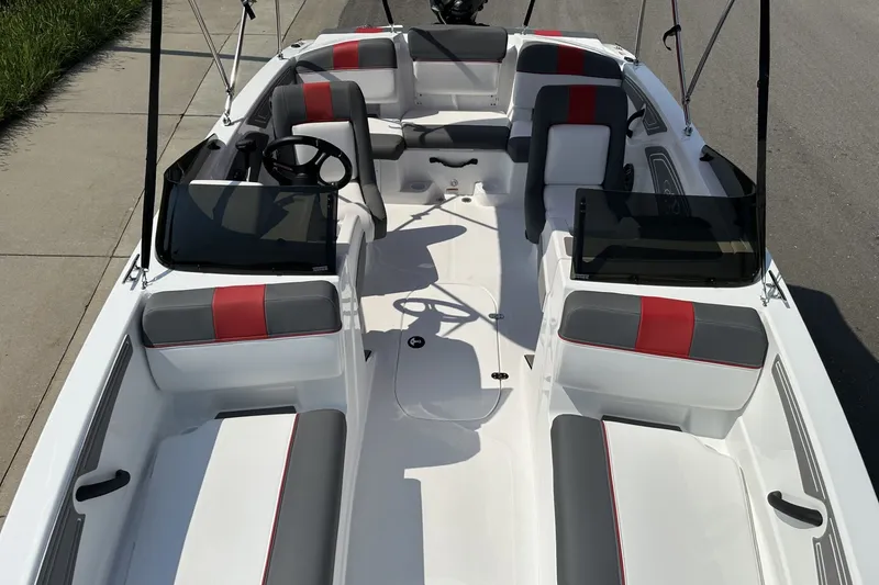 Slide: The Image of 2027 Tahoe T21 boat interior with red and gray seating, steering wheel, and windshield. - 10