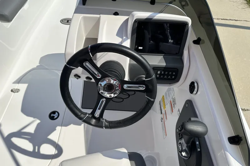 Slide: The Image of Steering wheel and dashboard of 2027 Tahoe T21 boat, featuring modern controls and display. - 19