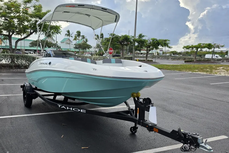 Slide: The Image of 2027 Tahoe T16 boat with canopy on trailer in parking lot. - 2