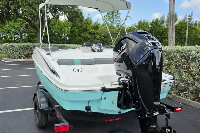 Slide: The Image of 2027 Tahoe T16 boat with Mercury engine, parked outdoors on a trailer. - 9