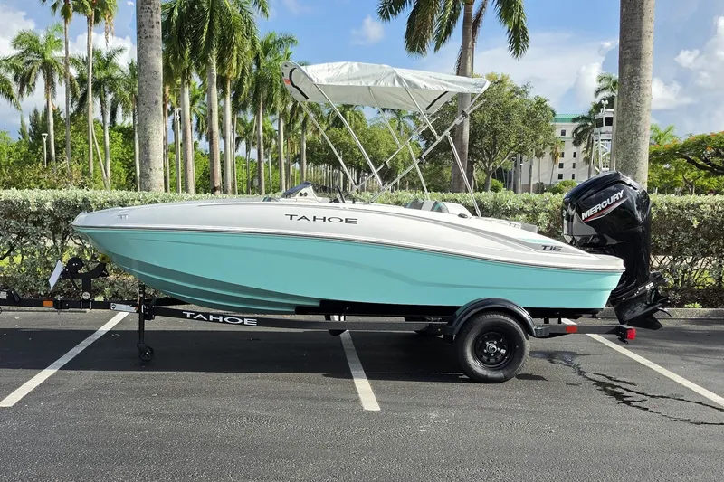The Image of 2027 Tahoe T16 boat with Mercury engine, parked under palm trees. - 0