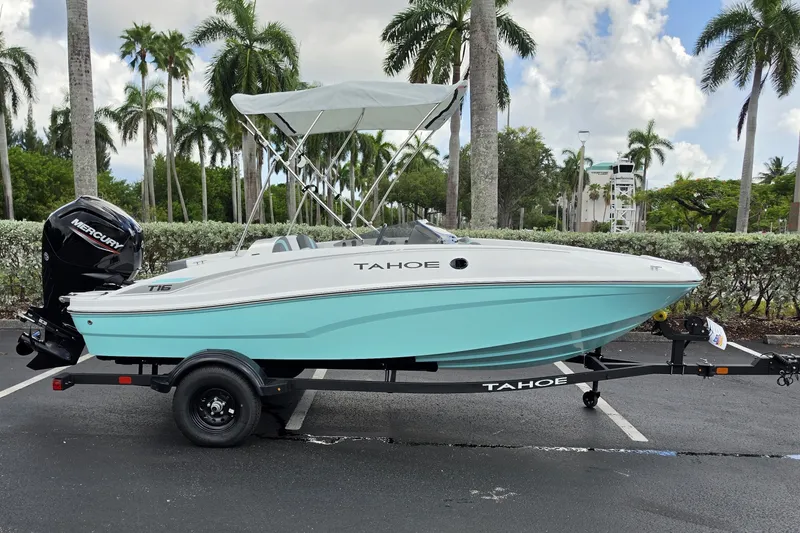 Slide: The Image of 2027 Tahoe T16 boat on trailer, parked with palm trees in the background. - 1