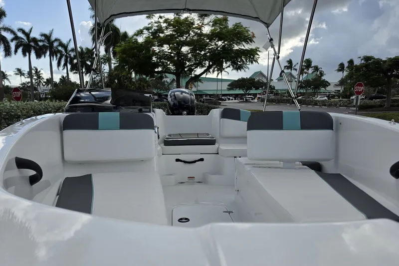 Slide: The Image of 2027 Tahoe T16 boat interior with seating, canopy, and motor, set against a tropical backdrop. - 7