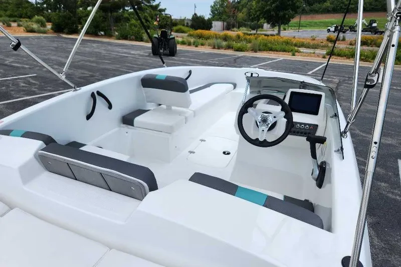 Slide: The Image of 2027 Tahoe T16 boat interior with modern steering and seating in a parking lot. - 13