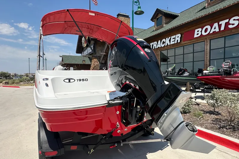 Slide: The Image of Red and white 2027 Tahoe 1950 boat with outboard motor at dealership. - 10