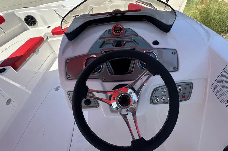 Slide: The Image of Steering console of a 2027 Tahoe 1950 boat with red and white seating. - 19