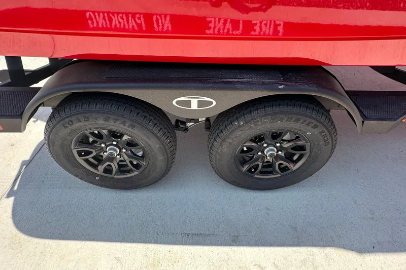 Slide: The Image of Red Tahoe 1950 trailer with black wheels, parked on concrete, "No Parking" sign reflected. - 6