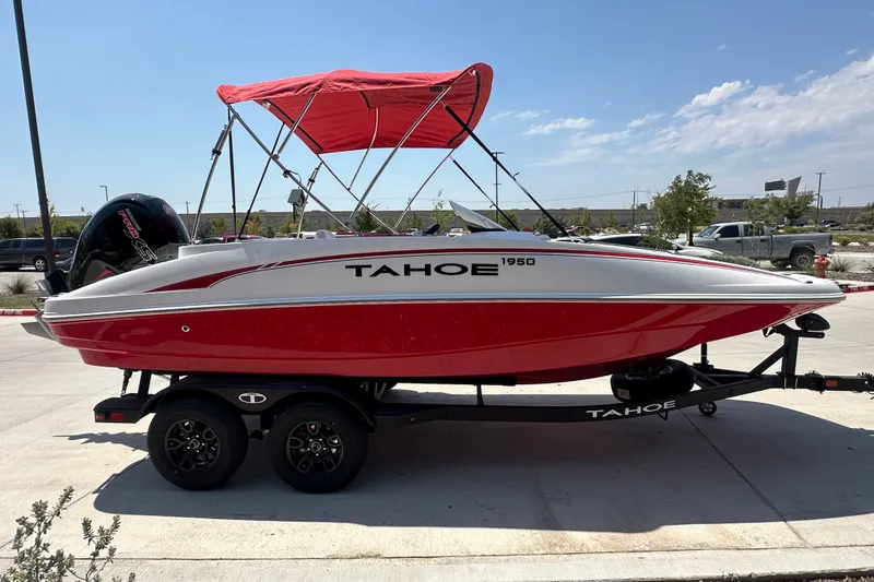 Slide: The Image of Red and white 2027 Tahoe 1950 boat with canopy on trailer in parking lot. - 5
