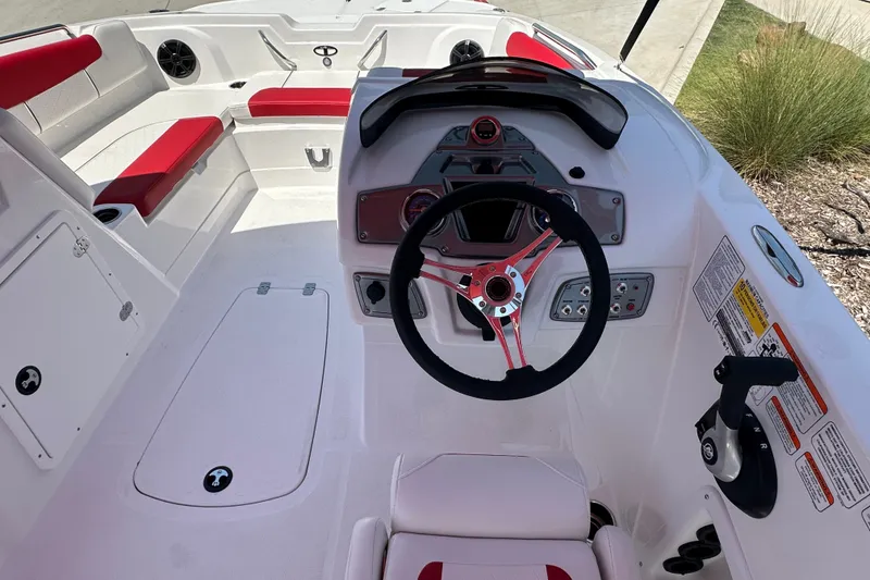 Slide: The Image of Steering console of a 2027 Tahoe 1950 boat with red and white seating. - 12