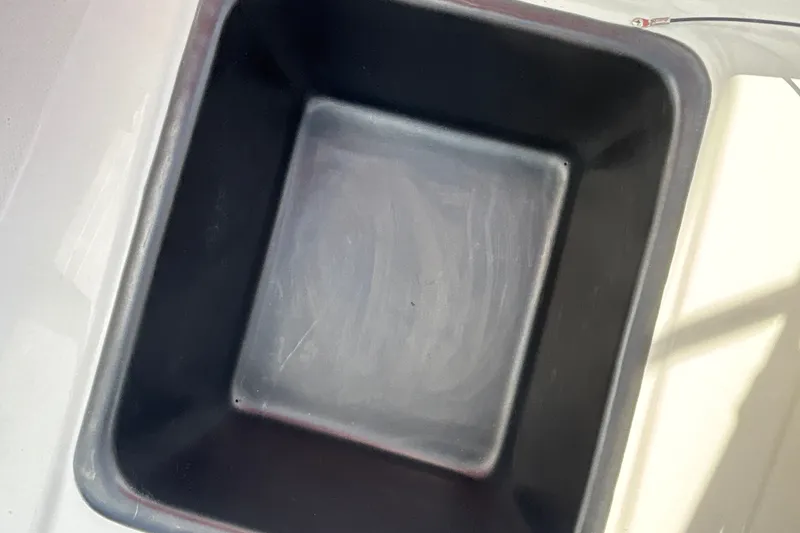 Slide: The Image of Empty black storage compartment in a 2027 Tahoe T18 boat. - 23