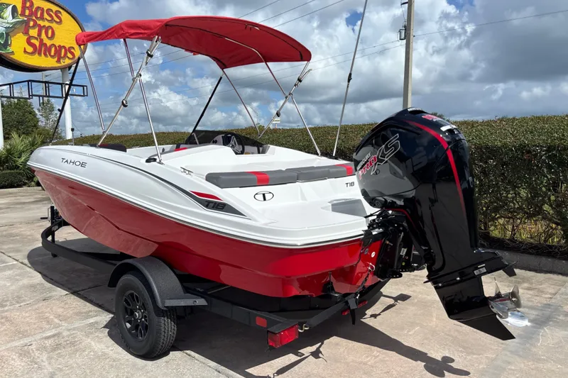 Slide: The Image of 2027 Tahoe T18 boat with red canopy at Bass Pro Shops, featuring a powerful outboard motor. - 2
