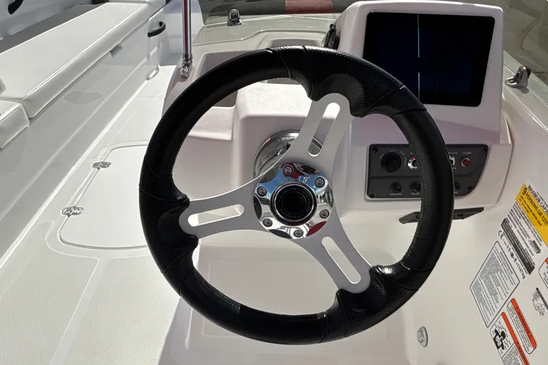 Slide: The Image of Steering wheel and dashboard of 2027 Tahoe T18 boat, featuring modern controls and sleek design. - 13