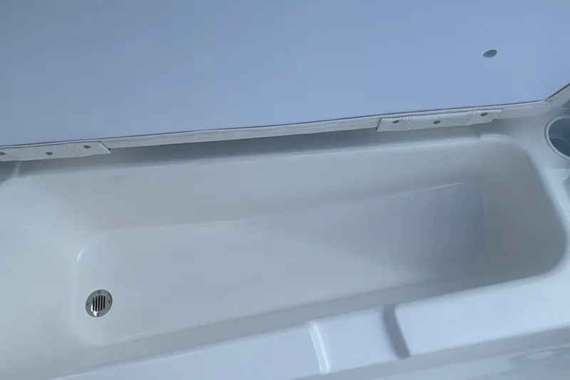 Slide: The Image of 2027 Tahoe T18 boat storage compartment with drain, open lid view. - 19
