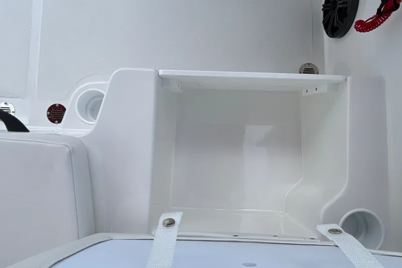 Slide: The Image of Interior view of a 2027 Tahoe T18 boat compartment with white finish and storage space. - 18