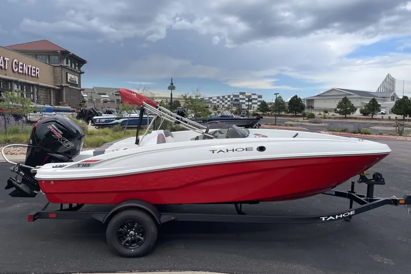Slide: The Image of 2027 Tahoe T18 boat with red hull on trailer, parked outside a boat center. - 5