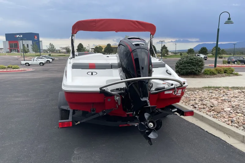 Slide: The Image of 2027 Tahoe T18 boat with red canopy and outboard motor in a parking lot. - 1