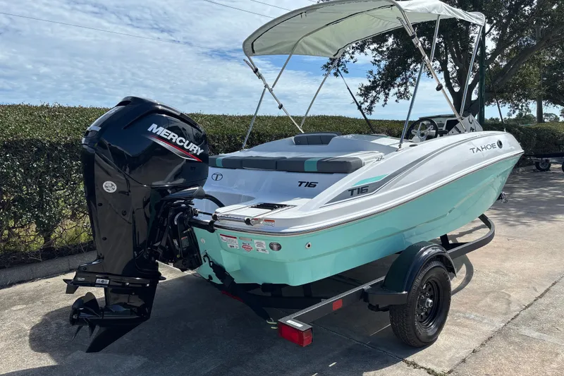 Slide: The Image of 2027 Tahoe T16 boat with Mercury engine, parked on a trailer, under a clear sky. - 5