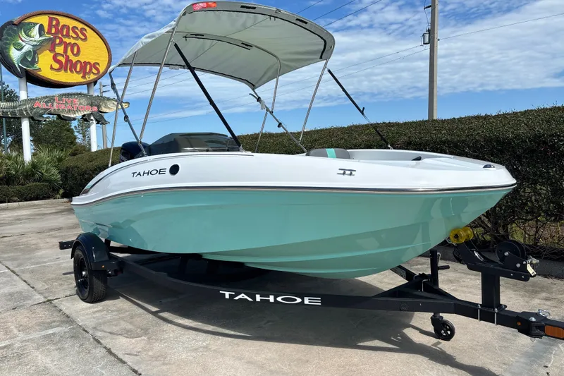 Slide: The Image of 2027 Tahoe T16 boat on trailer at Bass Pro Shops, under clear sky. - 4