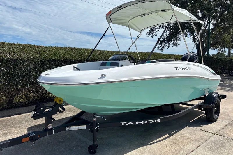 Slide: The Image of 2027 Tahoe T16 boat with canopy on trailer, parked outdoors. - 1