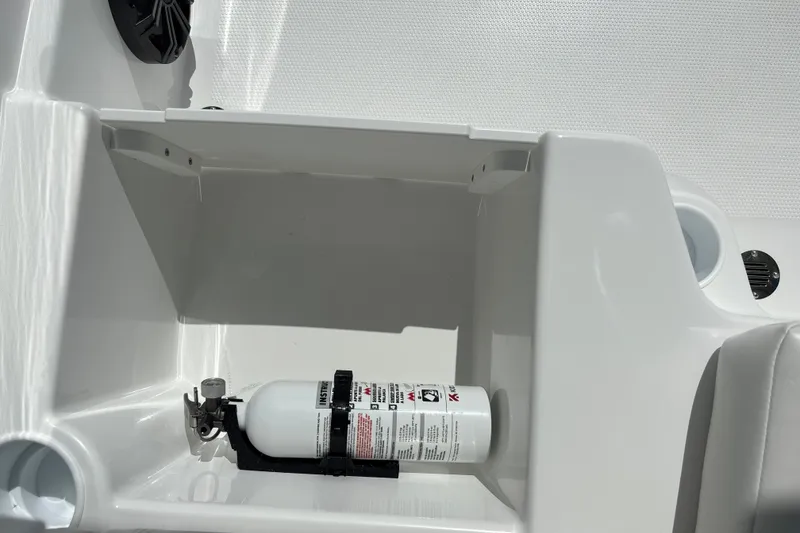 Slide: The Image of Fire extinguisher in 2027 Tahoe T16 boat compartment, white interior. - 24