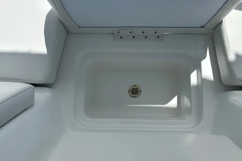 Slide: The Image of 2027 Tahoe T16 boat storage compartment with white cushioned seating. - 25