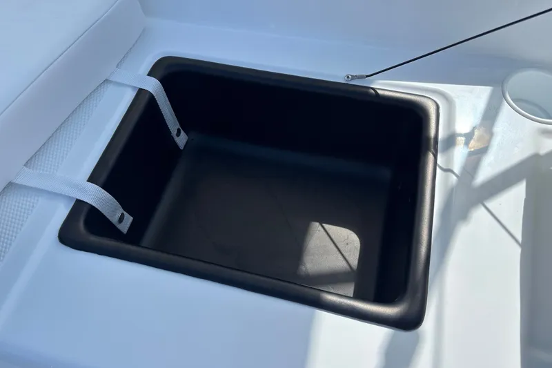 Slide: The Image of Storage compartment in a 2027 Tahoe T16 boat, featuring a black interior and white straps. - 29