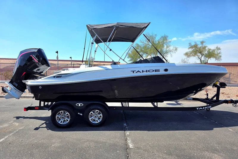 The Image of 2027 Tahoe T21 boat on trailer, black and white design, with outboard motor and canopy. - 0
