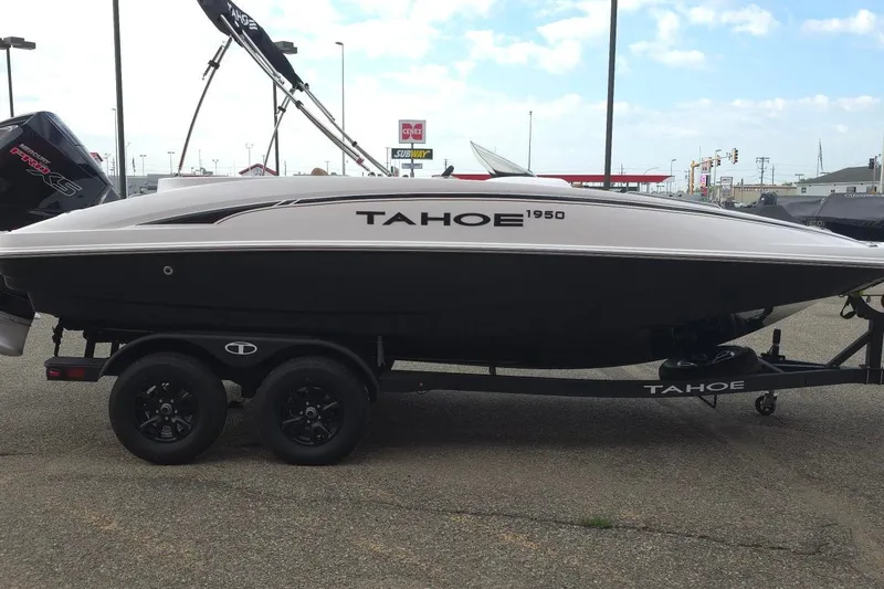 Slide: The Image of 2027 Tahoe 1950 boat on trailer, parked outdoors, side view. - 4