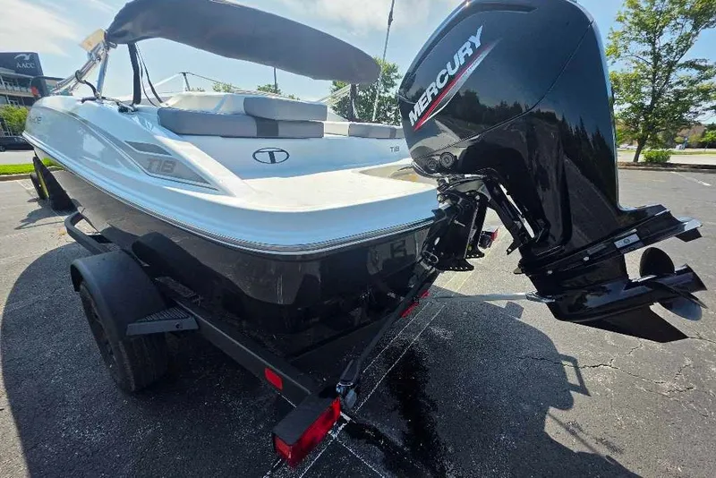 Slide: The Image of 2027 Tahoe T18 boat with Mercury outboard motor on a trailer in a parking lot. - 3