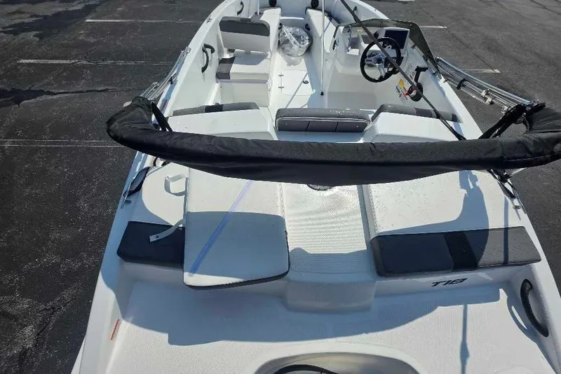 Slide: The Image of 2027 Tahoe T18 boat interior with seating and steering wheel, parked on asphalt. - 9
