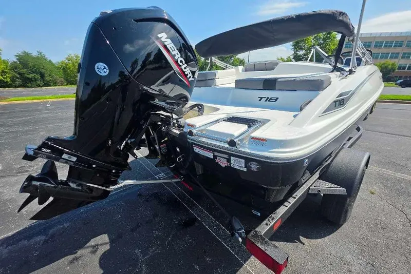 Slide: The Image of 2027 Tahoe T18 boat with Mercury engine on a trailer, parked outdoors. - 6