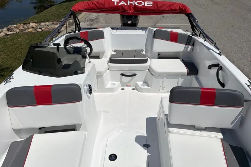 Slide: The Image of 2027 Tahoe T18 boat interior with red and gray seating, steering wheel, and windshield. - 7