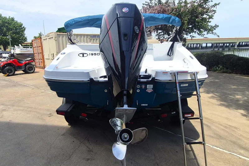 Slide: The Image of 2027 Tahoe 1950 boat with outboard motor and ladder, parked on concrete. - 6